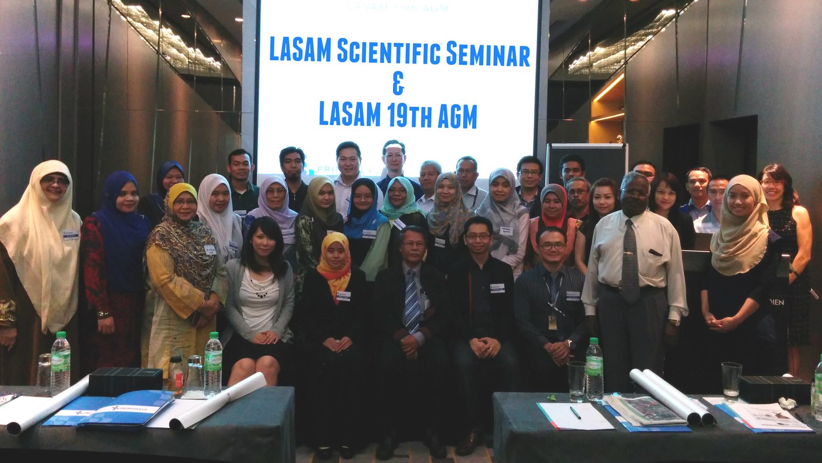 Group photo of participants in front of a screen reading LASAM Scientific Seminar and LASAM 19th AGM