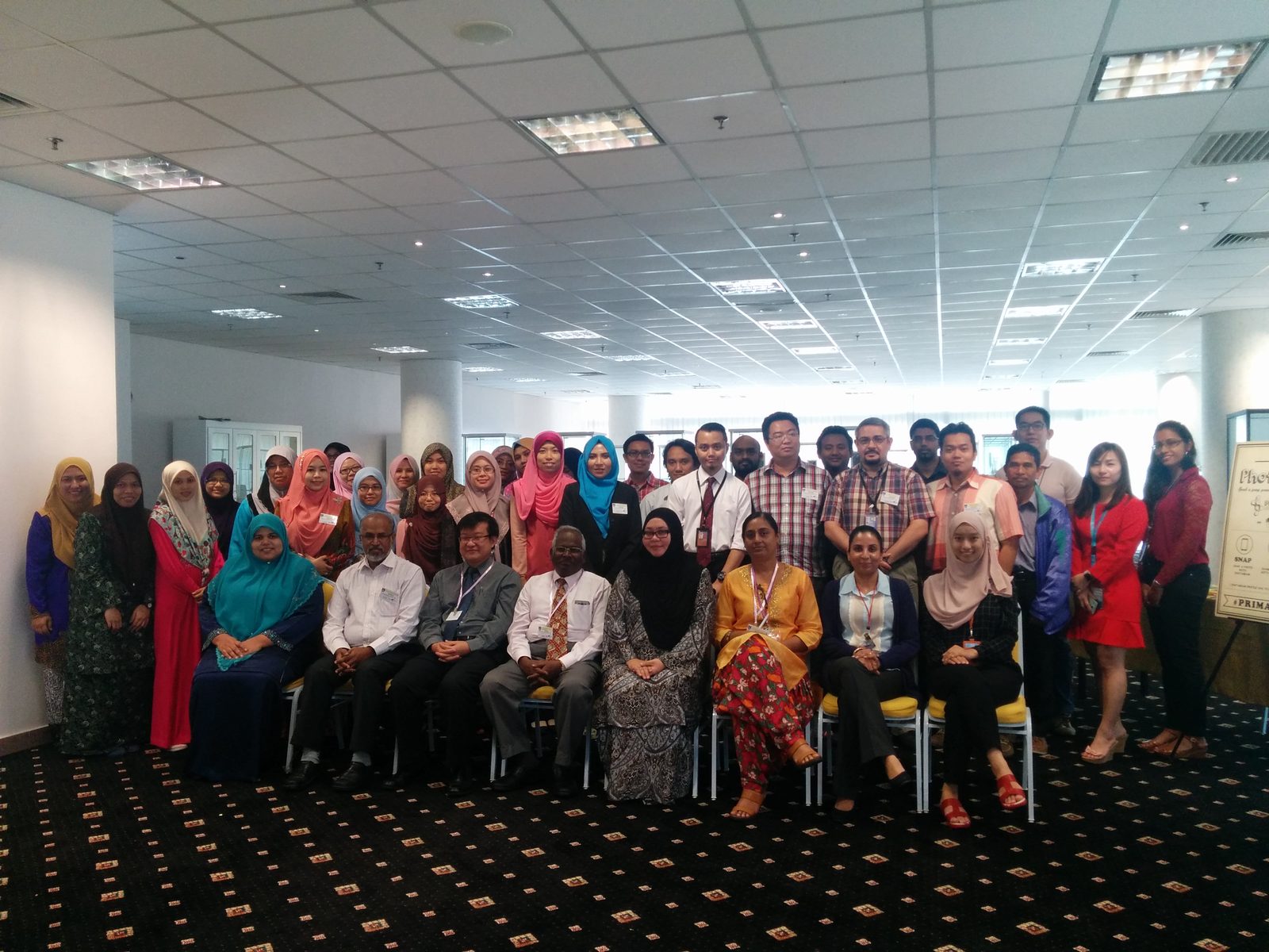 Group photo of workshop participants seated and standing in rows in the lecture room at UiTM Puncak Alam