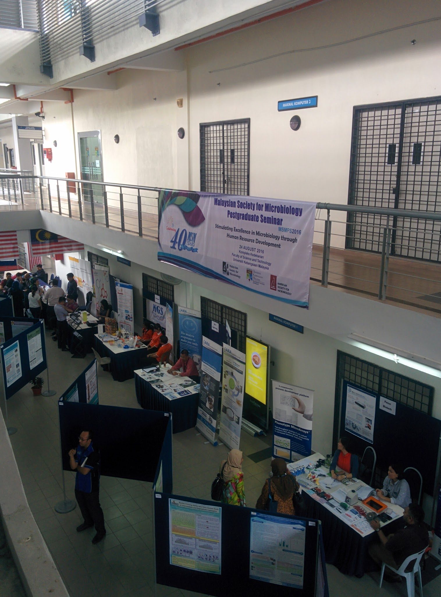 Poster boards and exhibitor tables in the faculty hall, under the MSMPS 2016 seminar banner