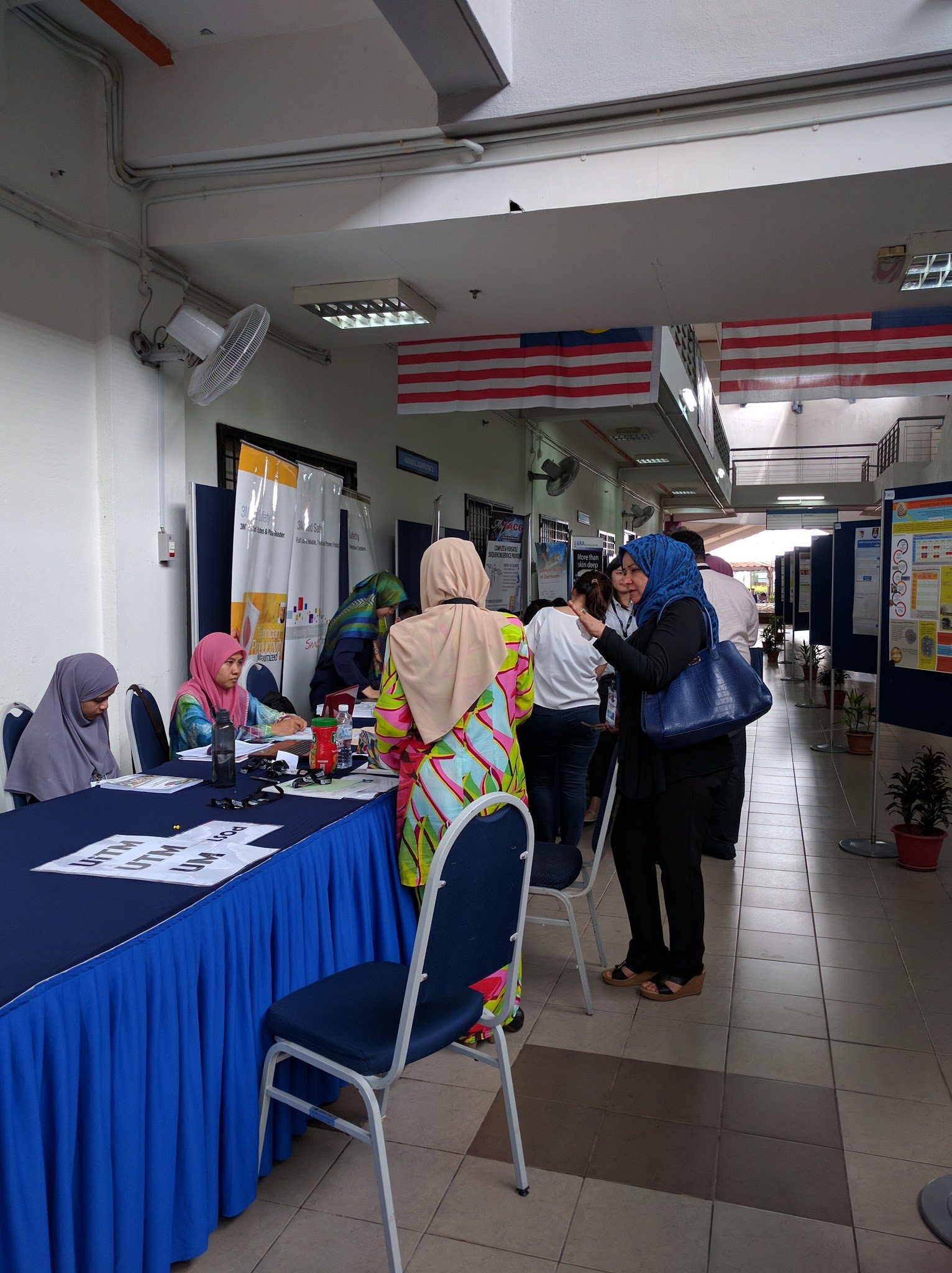 Registration desk with university name cards, as delegates arrive in the corridor of poster boards