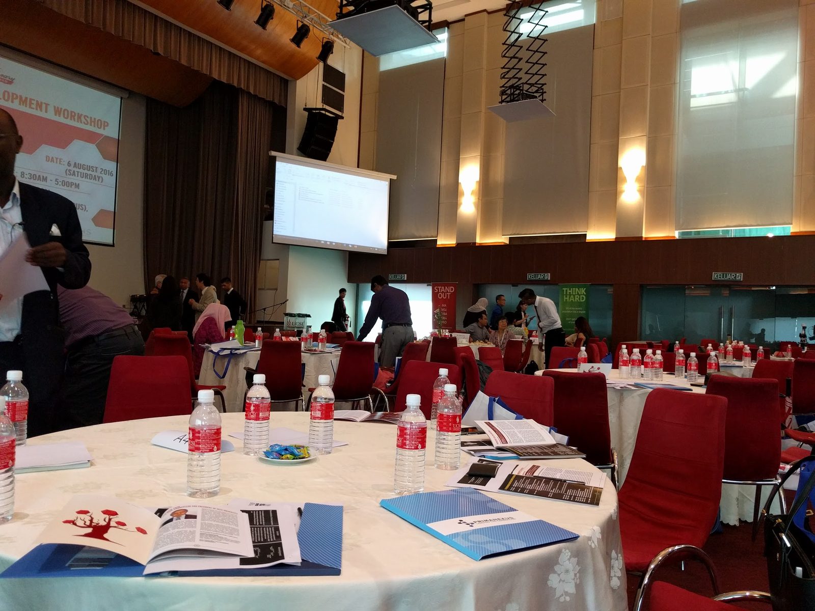 Round table set with water bottles, workshop booklets and a blue Prima Nexus folder