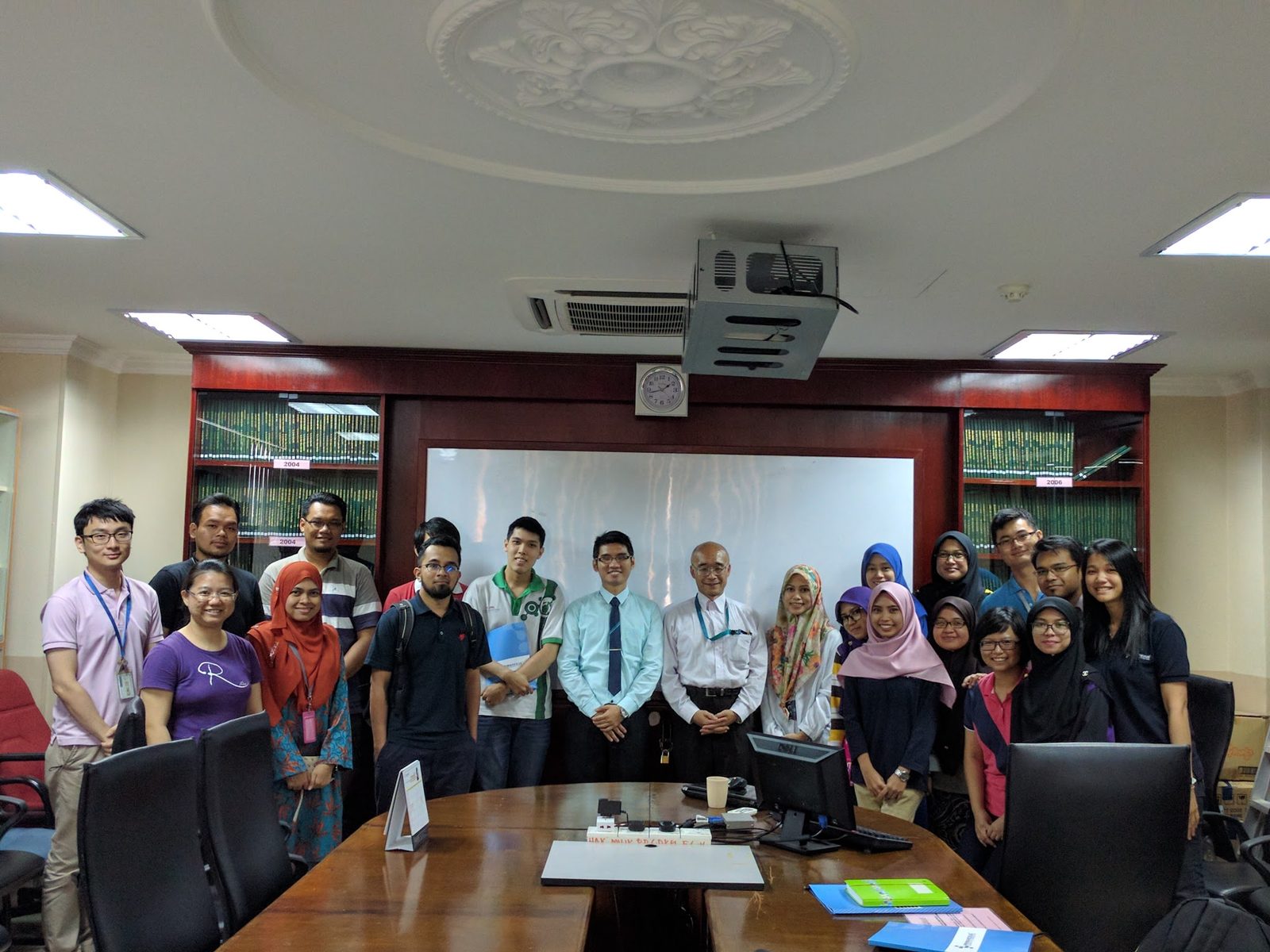 Workshop participants and trainers stand together for a group photo in a meeting room at UKM
