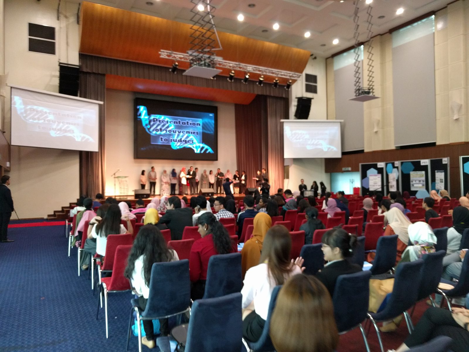 Wide view of the ballroom and stage as souvenirs are presented to the judges