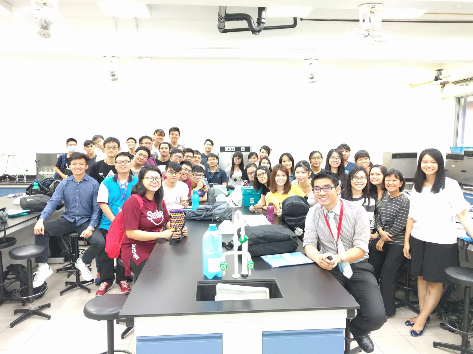 Group photo of seminar participants and the speaker behind a laboratory bench at TAR UC