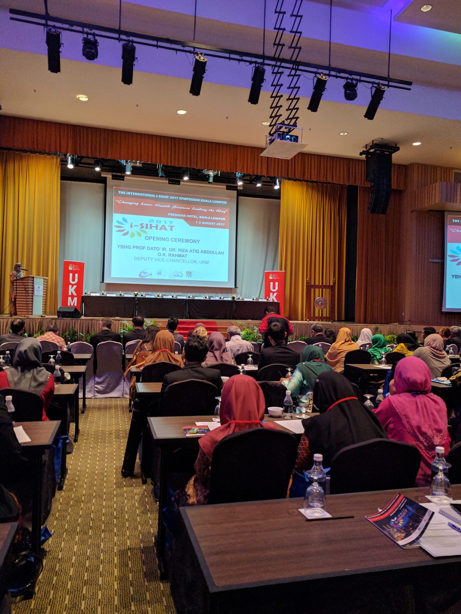 Delegates seated at rows of tables facing the stage and screen during the iSIHAT 2017 opening ceremony