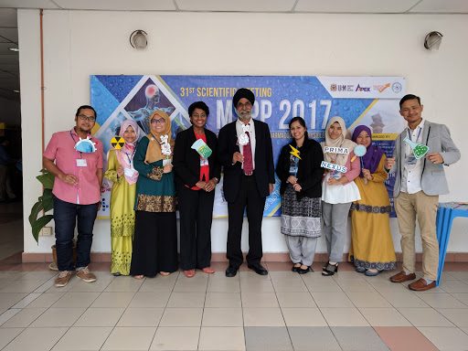 Nine delegates stand in a row with photo props in front of the MSPP 2017 banner.