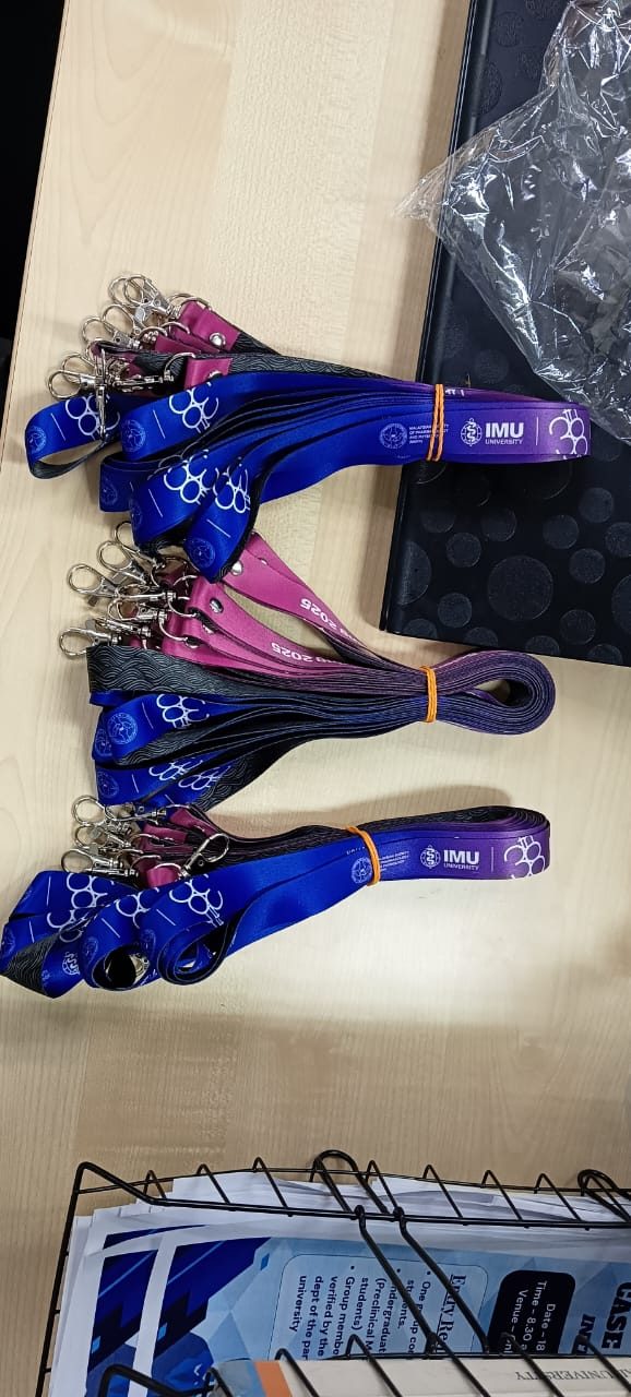 Bundles of blue and purple MSPP 2025 lanyards with the IMU University and MSPP logos, laid on a desk
