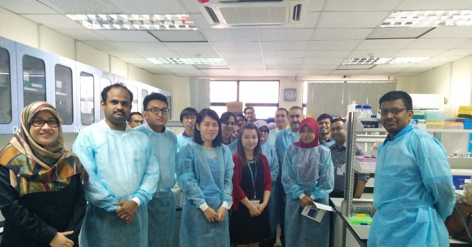 Workshop participants in blue laboratory gowns stand together in a laboratory at the Tissue Engineering Centre