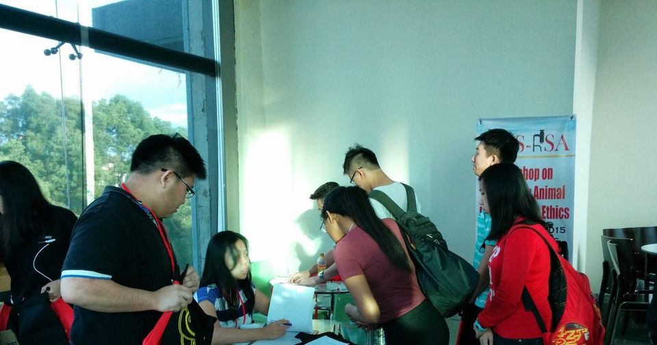 Participants sign in at the registration table, with the workshop banner standing behind them