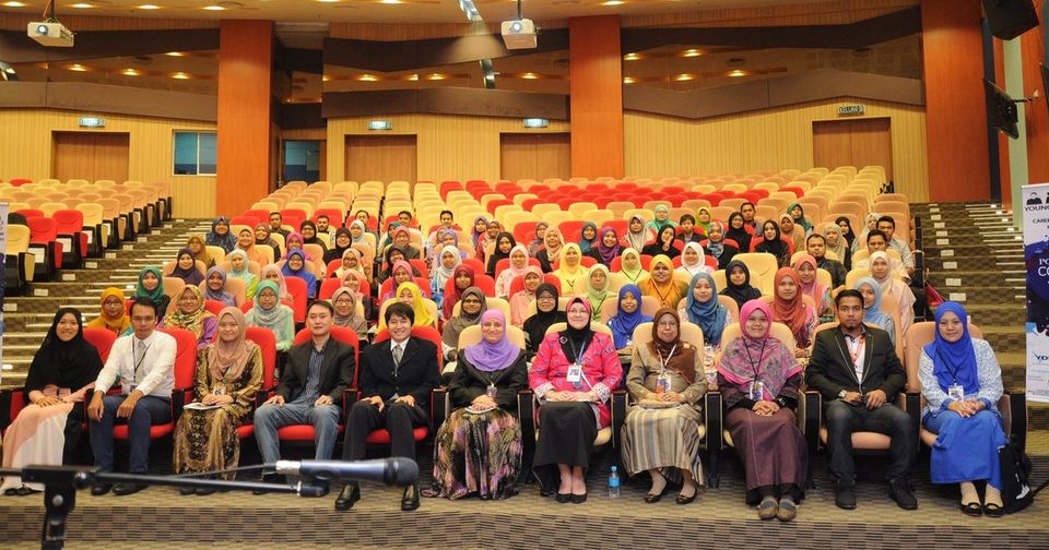 A large group of participants seated in rows for a group photo in the Main Auditorium at UiTM Sungai Buloh.