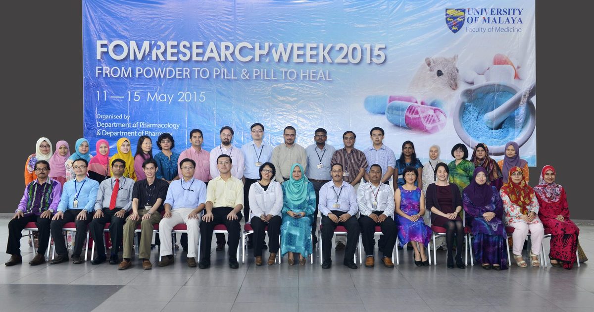 A large group seated and standing in two rows in front of the FOM Research Week 2015 backdrop