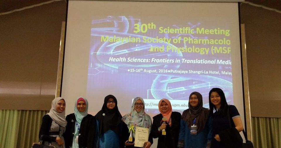 Seven delegates, two holding trophies, in front of the 30th MSPP Scientific Meeting title screen