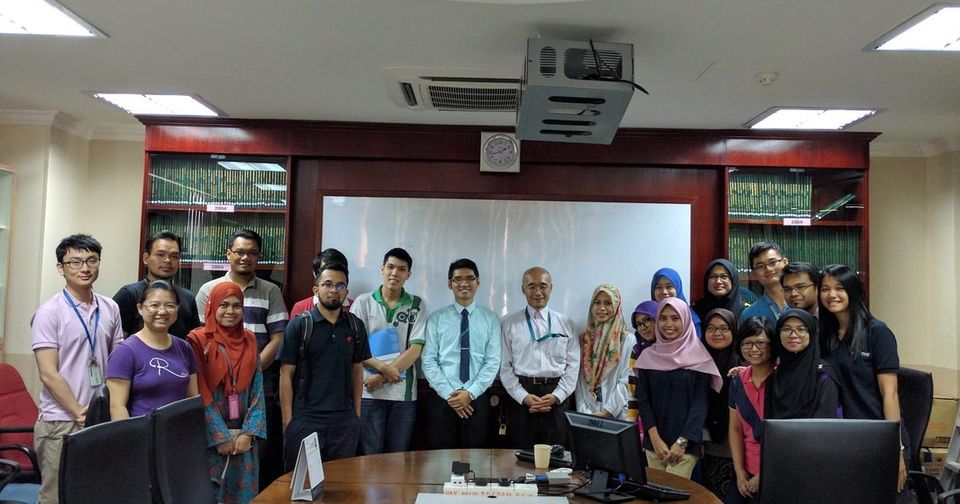 Workshop participants and trainers stand together for a group photo in a meeting room at UKM