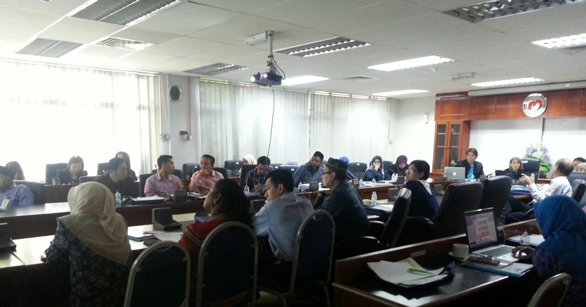 Workshop participants seated at desks in a large meeting room at the Institute for Medical Research