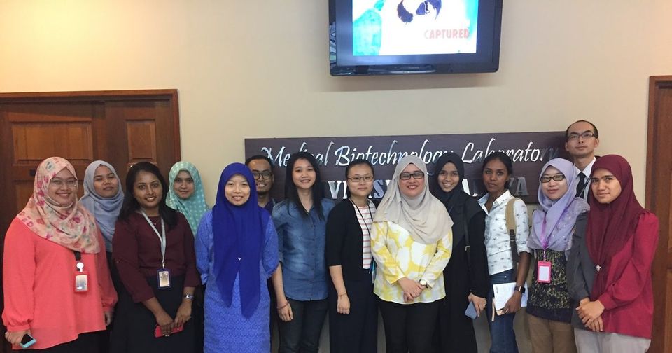 Group photo of the workshop participants standing in a row in front of the Medical Biotechnology Laboratory banner