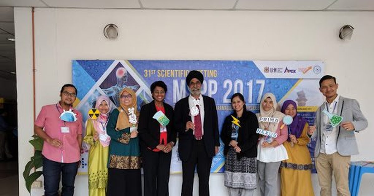 Nine delegates stand in a row with photo props in front of the MSPP 2017 banner.