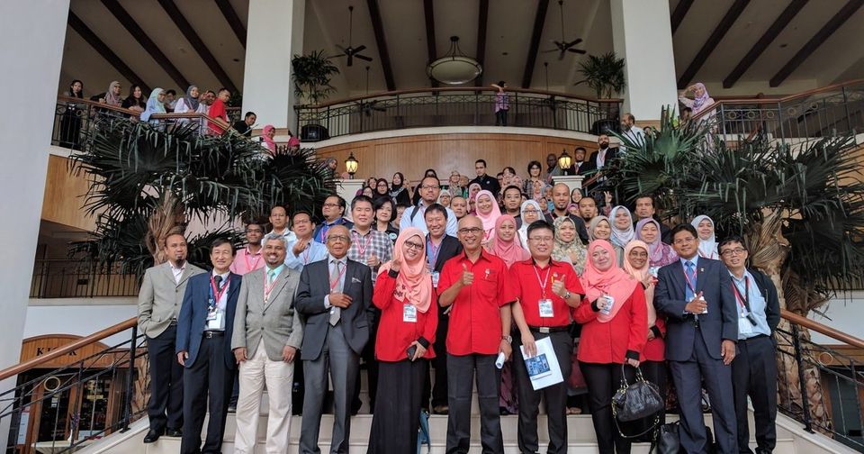 Speakers and participants in a group photo on a hotel staircase