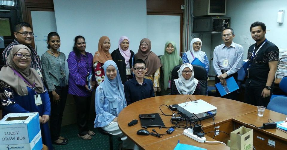 Seminar participants gather for a group photo around a meeting table