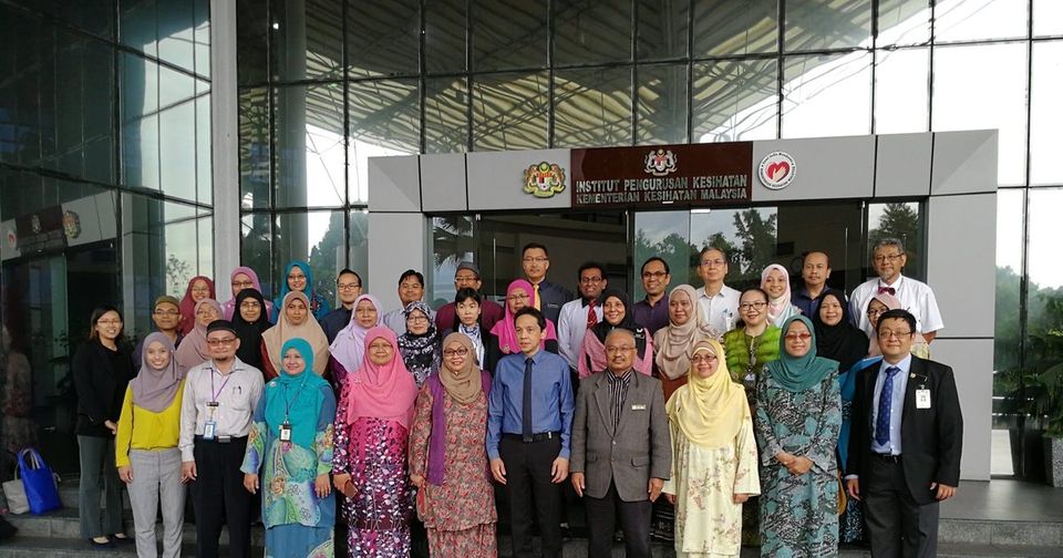 Workshop participants in a large group photo outside the Institute for Health Systems Research building