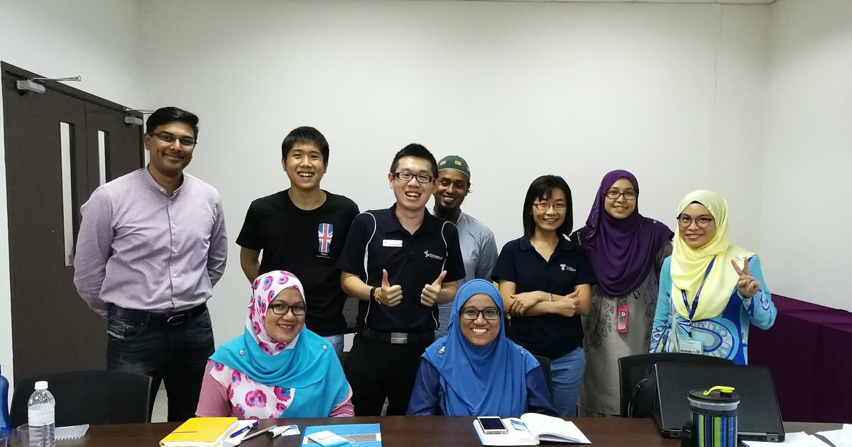Workshop participants and trainers in a group photo in a meeting room