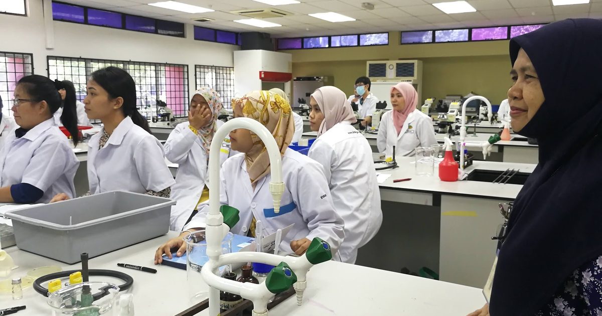 Participants in lab coats at the laboratory benches