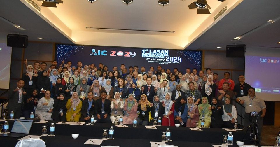 Full-room group photo of LIC 2024 participants in front of the LIC 2024 backdrop
