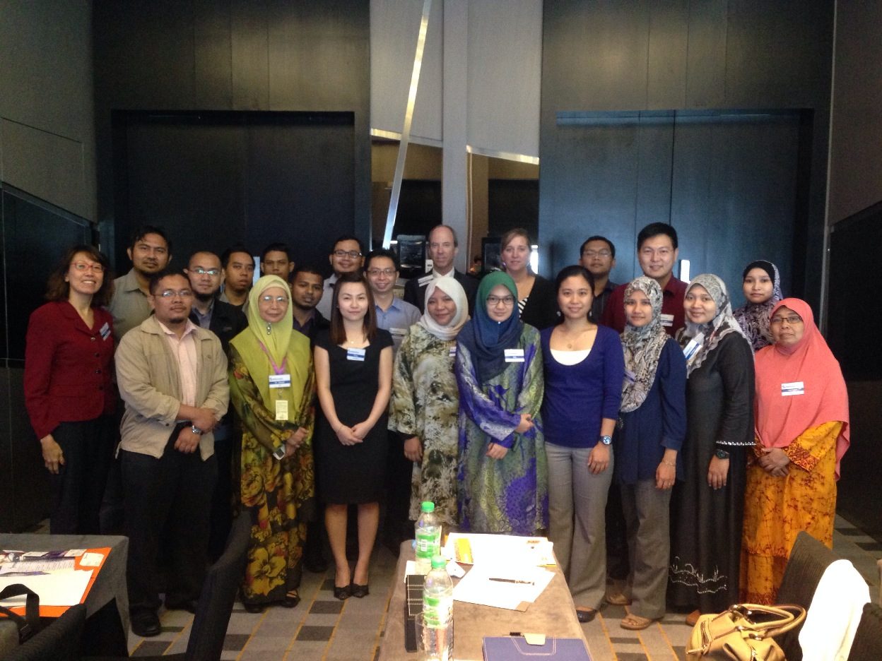 Group photo of participants standing together in a hotel meeting room