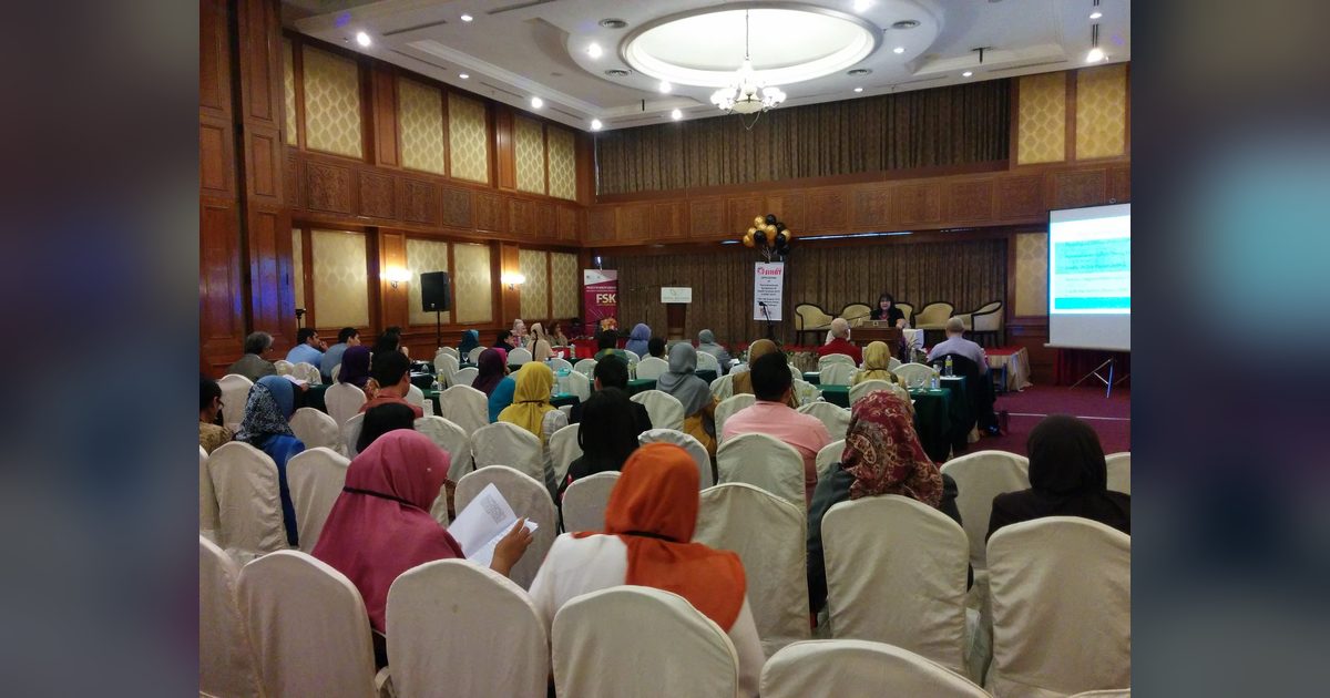 Delegates seated in the main hall facing a speaker at the lectern, with the i-SIHAT 2015 banner and a projector screen