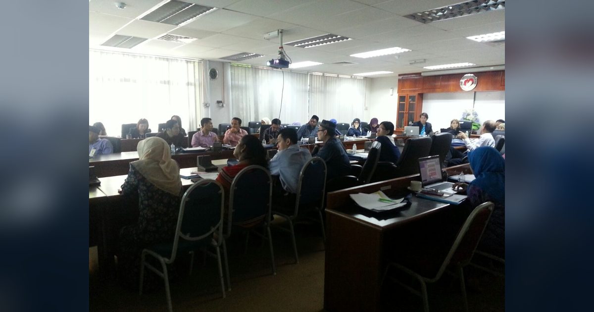 Workshop participants seated at desks in a large meeting room at the Institute for Medical Research