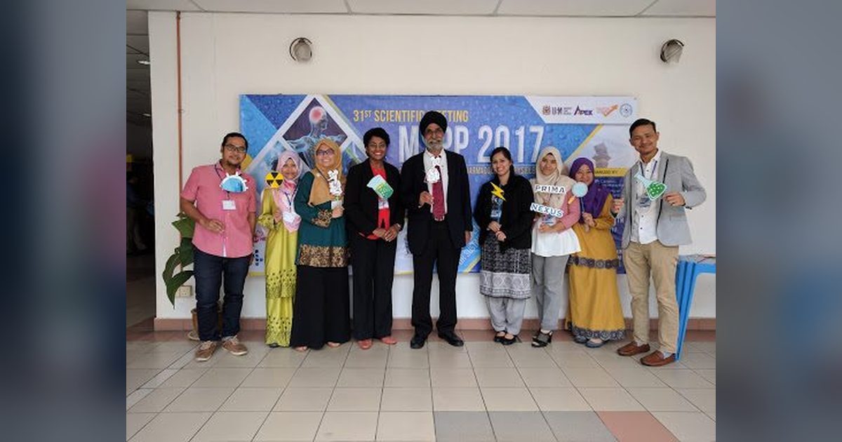 Nine delegates stand in a row with photo props in front of the MSPP 2017 banner.