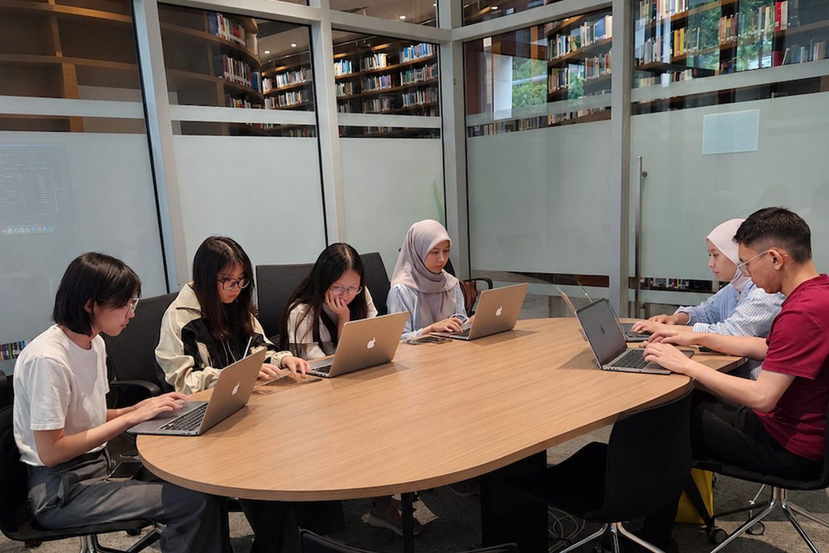 An open-plan meeting room with people working at a table