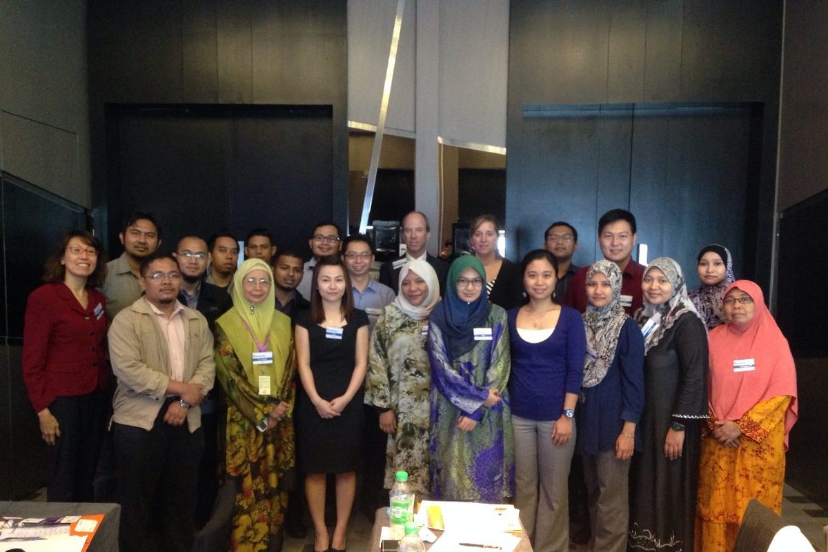 Group photo of participants standing together in a hotel meeting room