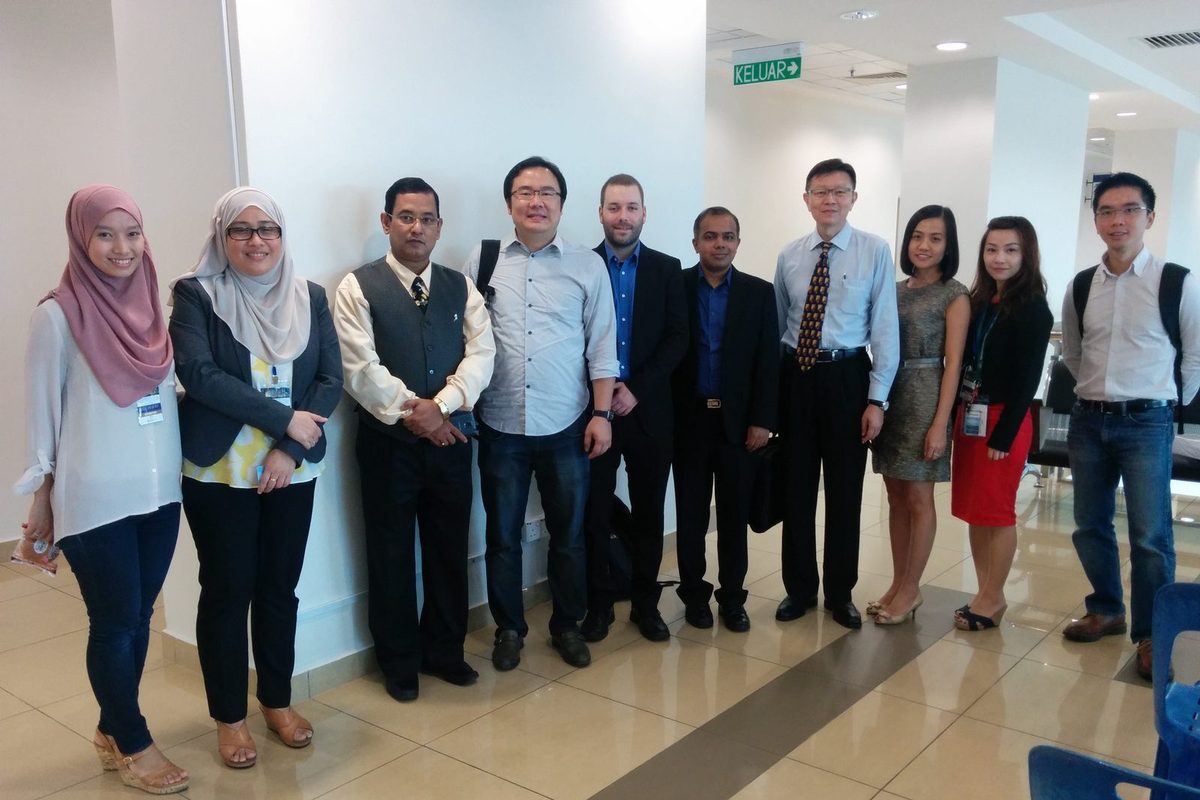 A group of ten people standing together in a corridor