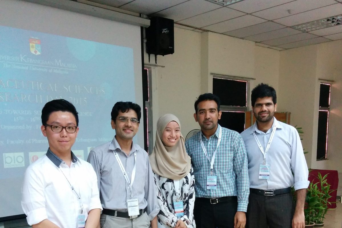 Five people standing in front of the Pharmaceutical Sciences Research Day 2015 title slide