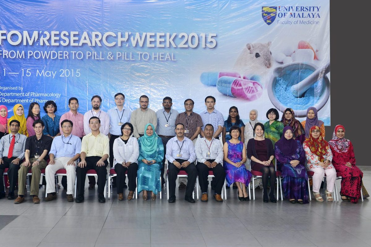 A large group seated and standing in two rows in front of the FOM Research Week 2015 backdrop