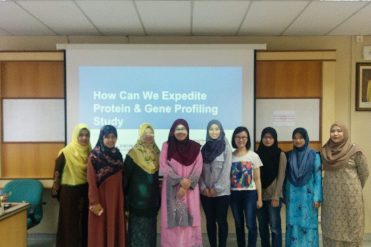 A group of nine women standing in front of a screen showing the title How Can We Expedite Protein & Gene Profiling Study