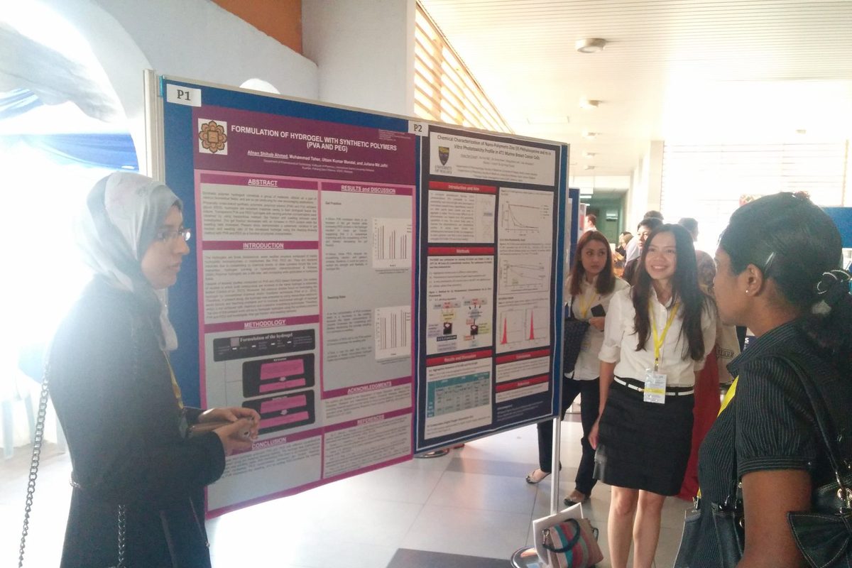 Delegates talk in front of research posters during the poster session