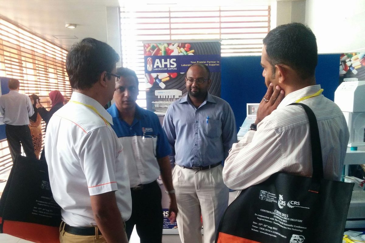 Delegates talk at a supplier booth in the exhibition area