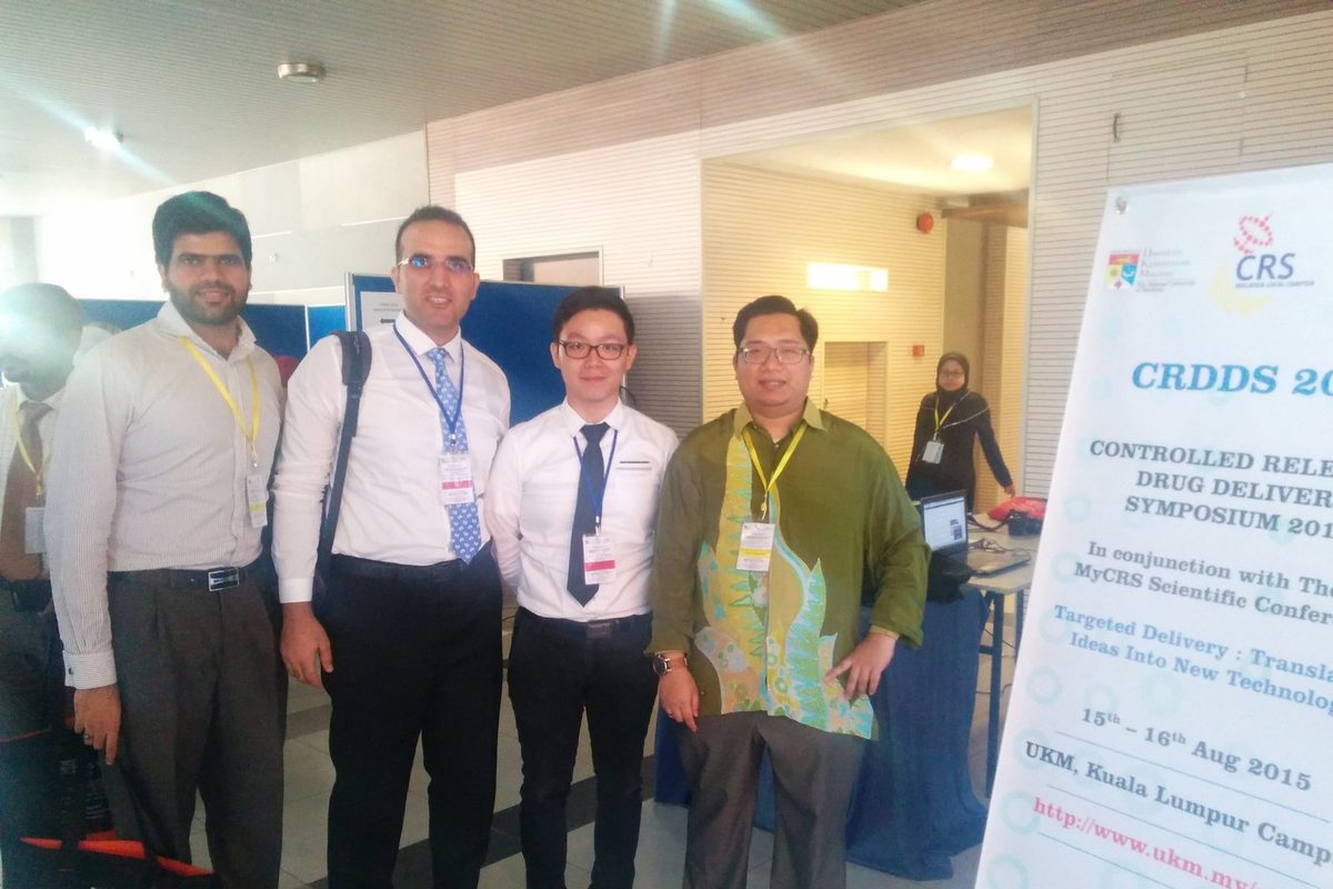 Four delegates stand together at the symposium