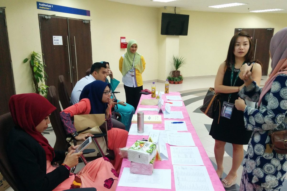 People at the seminar's registration desk, with attendees standing nearby