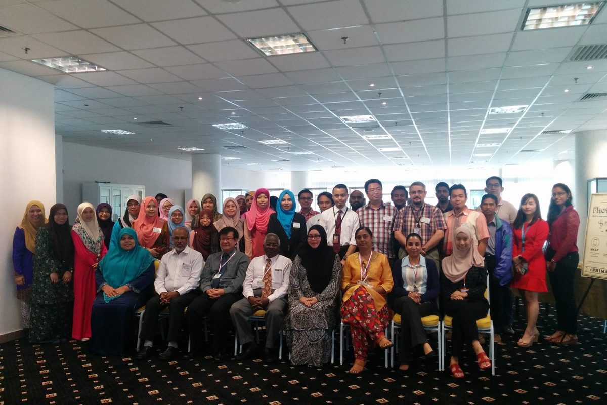 Group photo of workshop participants seated and standing in rows in the lecture room at UiTM Puncak Alam