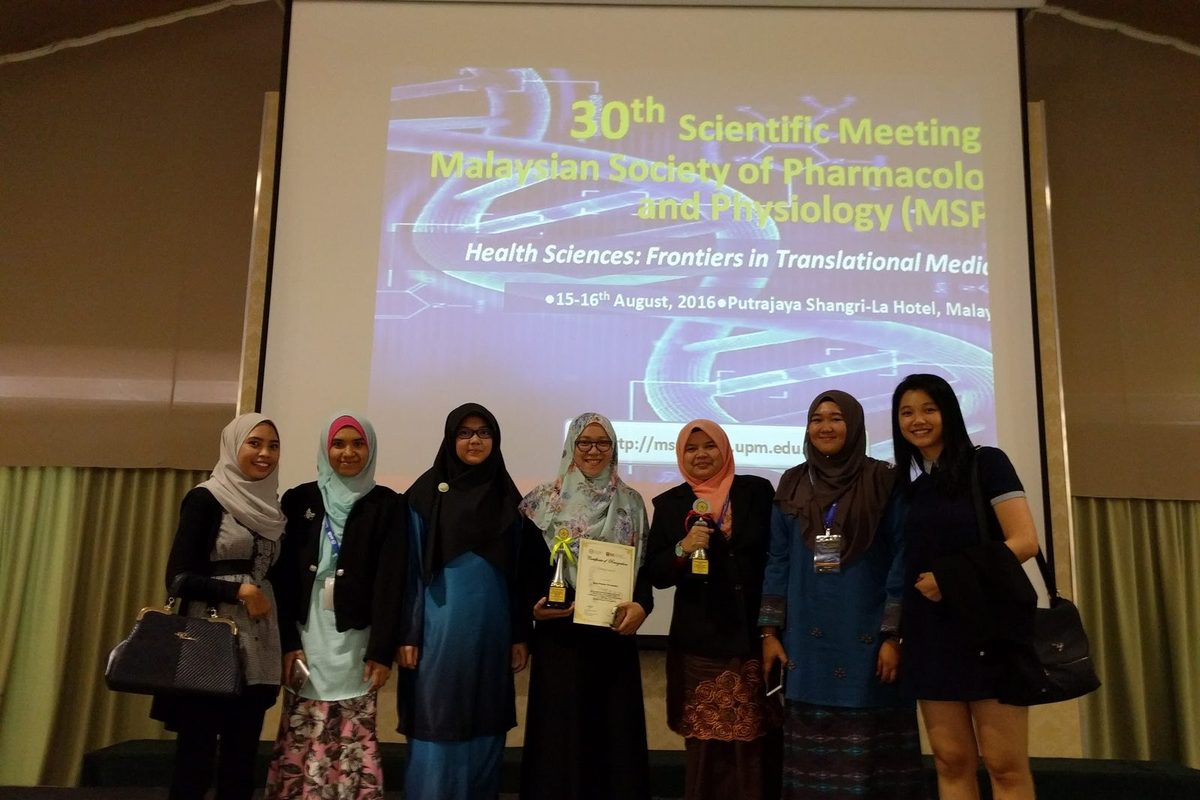 Seven delegates, two holding trophies, in front of the 30th MSPP Scientific Meeting title screen