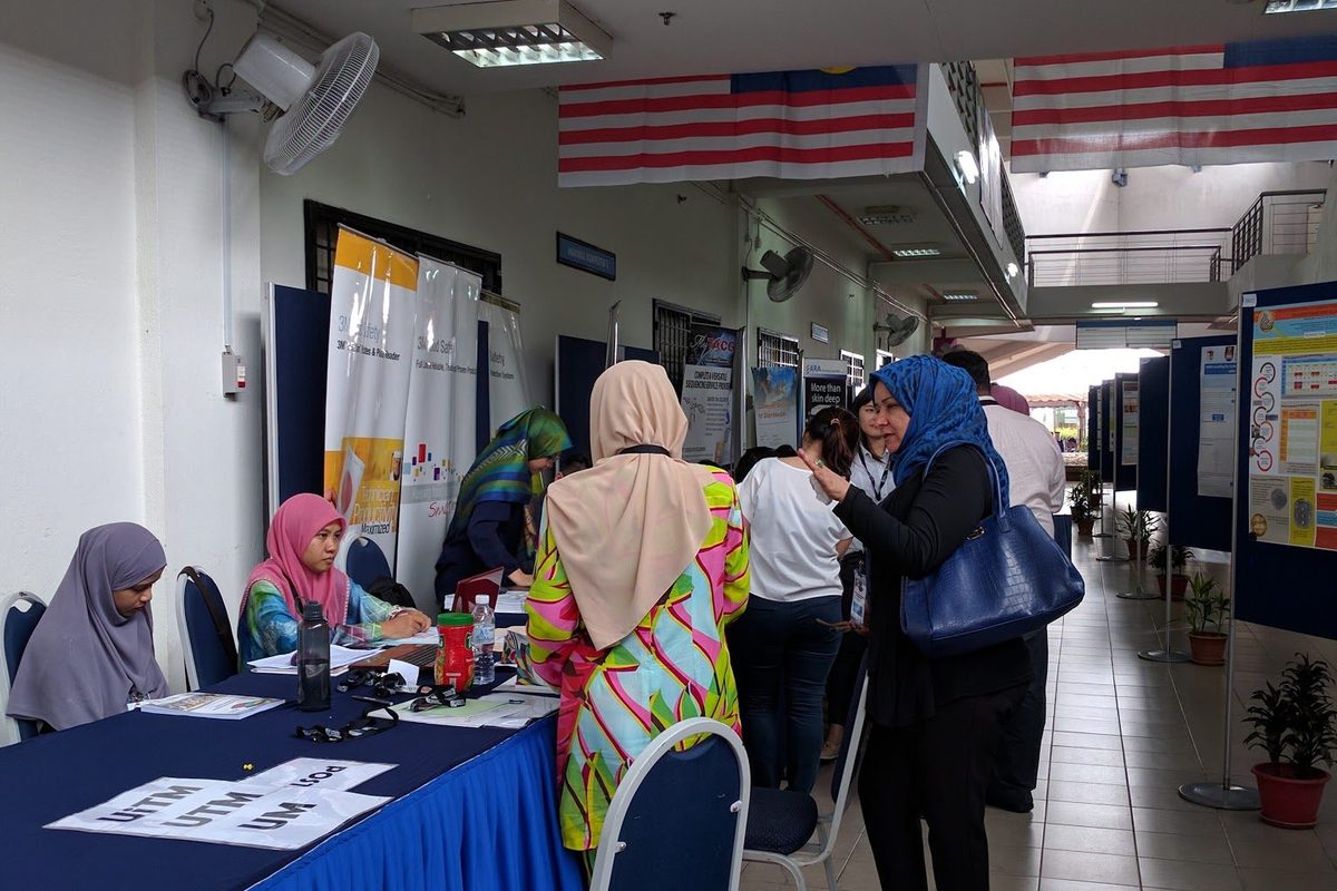 Registration desk with university name cards, as delegates arrive in the corridor of poster boards