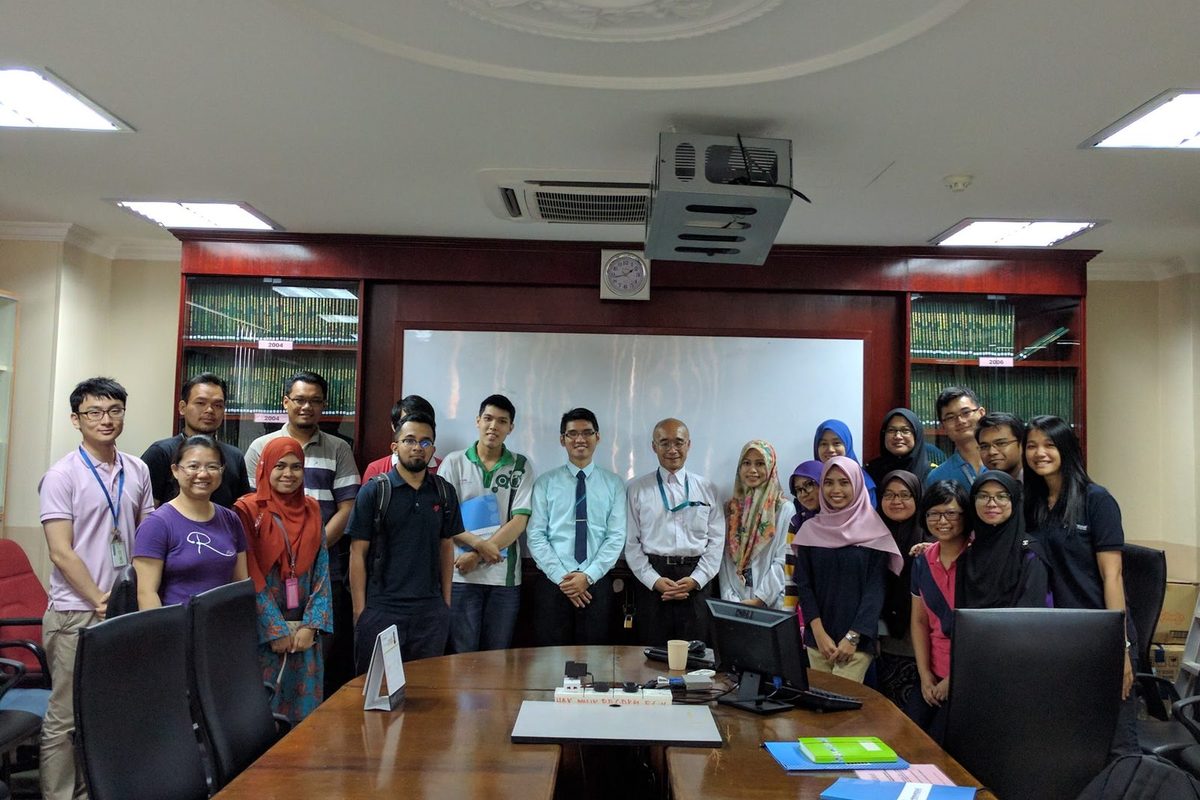 Workshop participants and trainers stand together for a group photo in a meeting room at UKM
