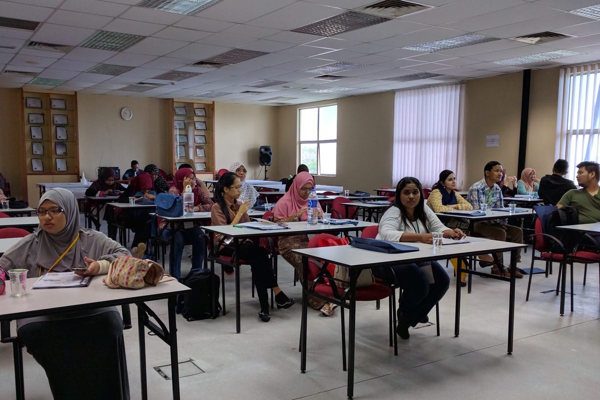 Participants seated at desks in the lecture room