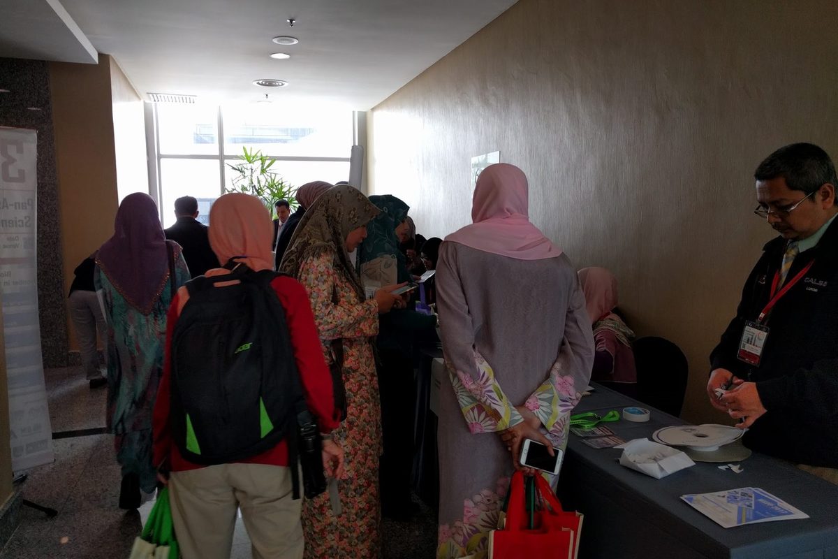 Delegates standing at a table in the foyer during a break