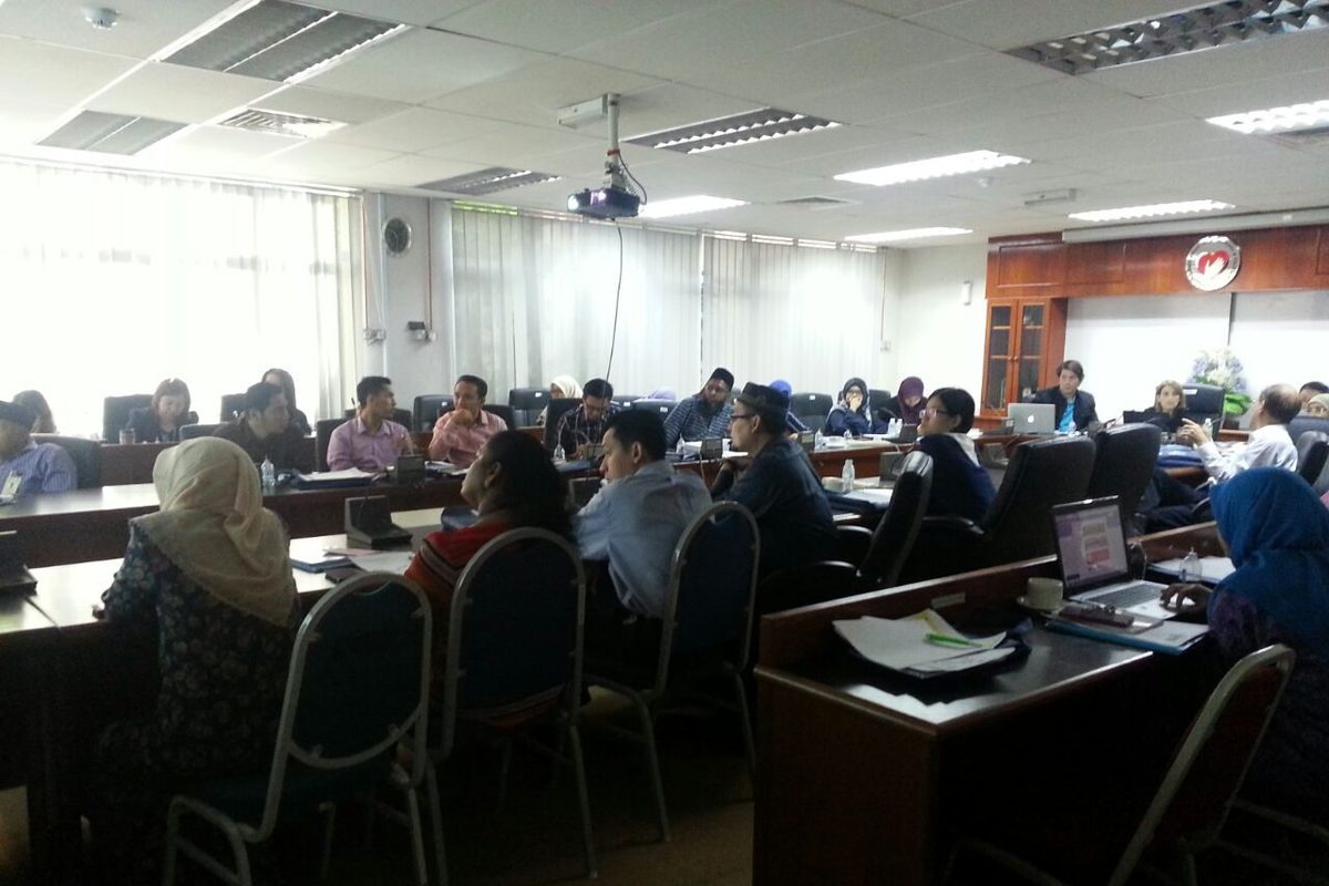 Workshop participants seated at desks in a large meeting room at the Institute for Medical Research