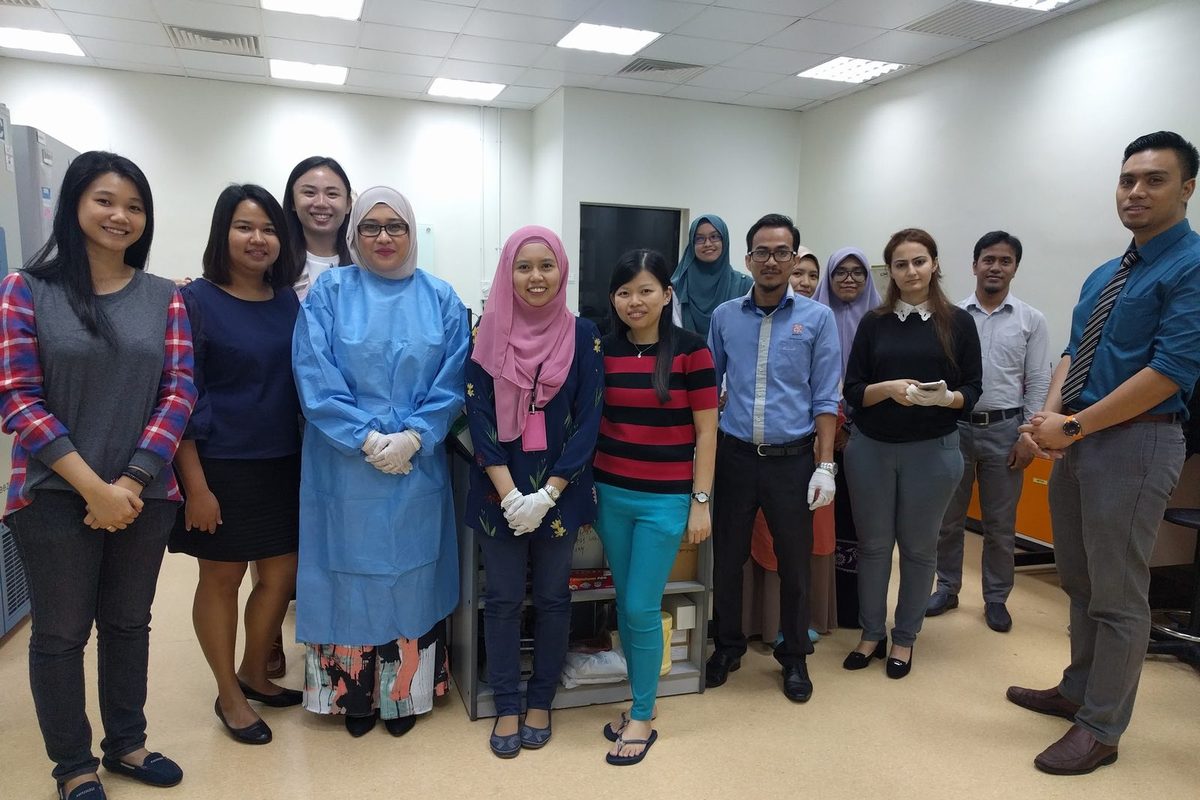 Workshop participants and trainers stand together for a group photo in a laboratory