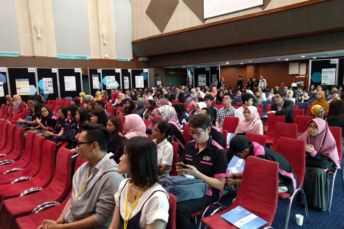 Seated audience in the ballroom, with poster boards behind them