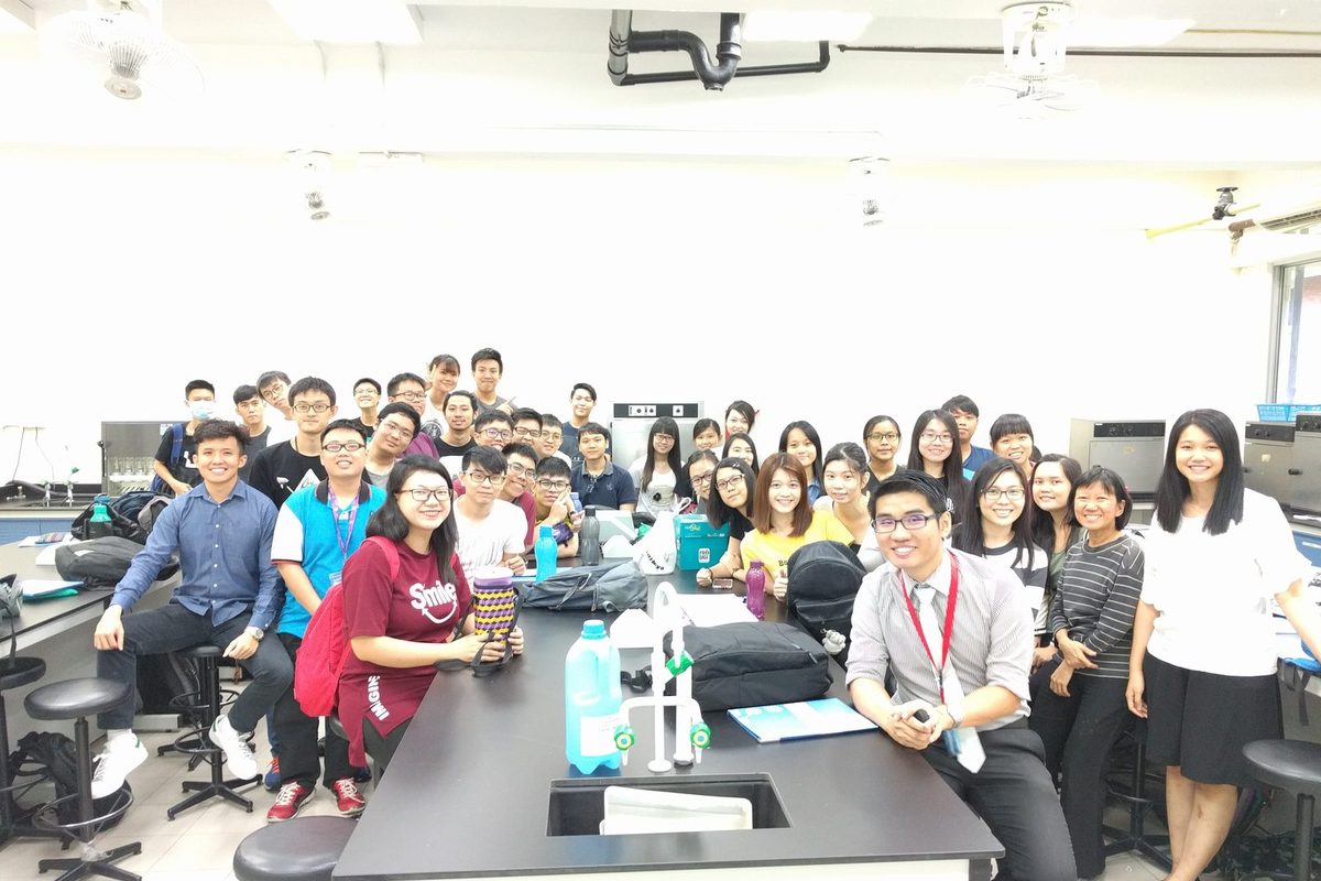 Group photo of seminar participants and the speaker behind a laboratory bench at TAR UC